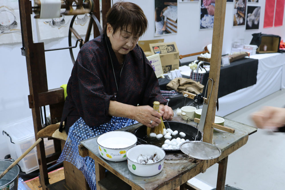 繭から糸を紡ぐ糸取り