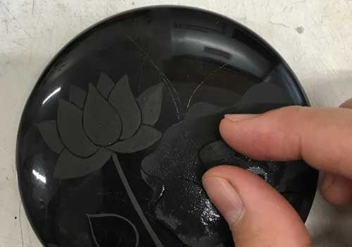 A maki-e lacquer incense holder with a lotus design is polished carefully with Suruga charcoal.